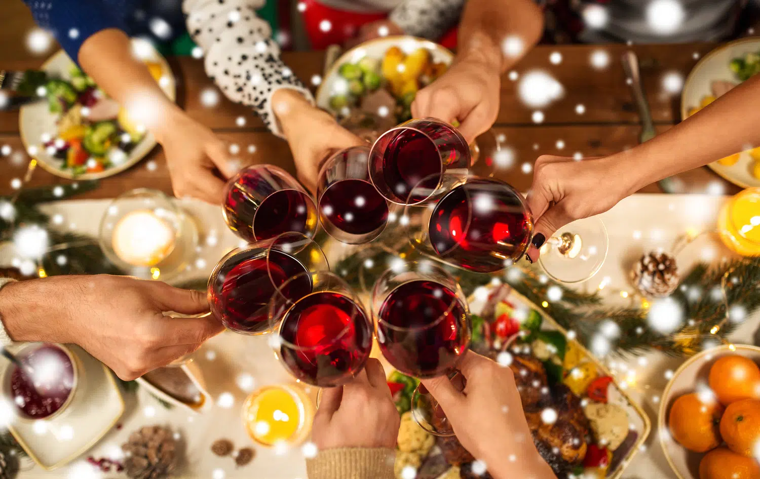 People cheersing with holiday lights in background